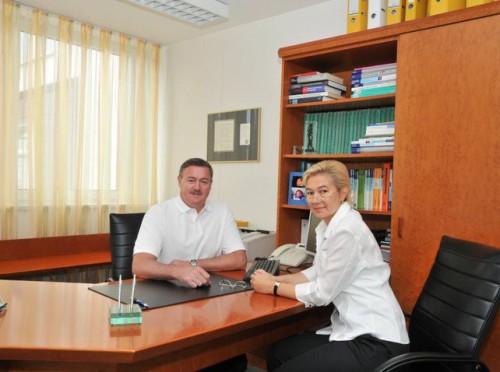 Dr. Julia Hedrich und Dr. Hans Hedrich sitzen zusammen am Schreibtisch im Besprechungszimmer.